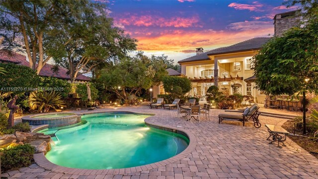 12483 Grand Oaks Dr, Davie, FL 33330 - pool at dusk with a patio and a pool with connected hot tub