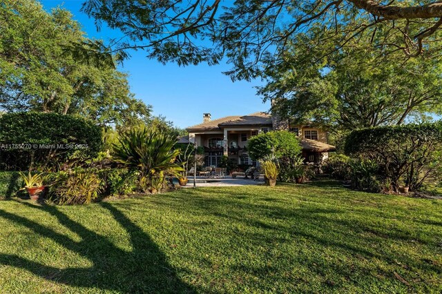 12483 Grand Oaks Dr, Davie, FL 33330 - view of green lawn with a patio area