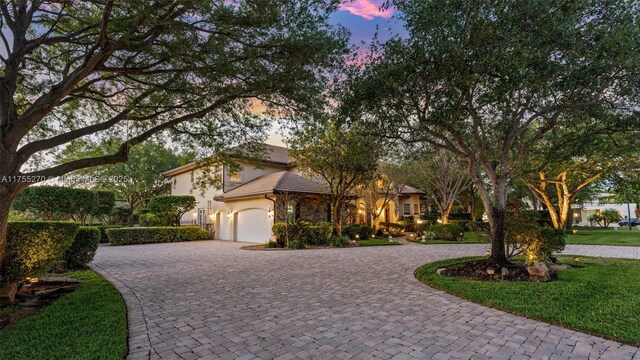 12483 Grand Oaks Dr, Davie, FL 33330 - view of front of property featuring curved driveway, stucco siding, and an attached garage