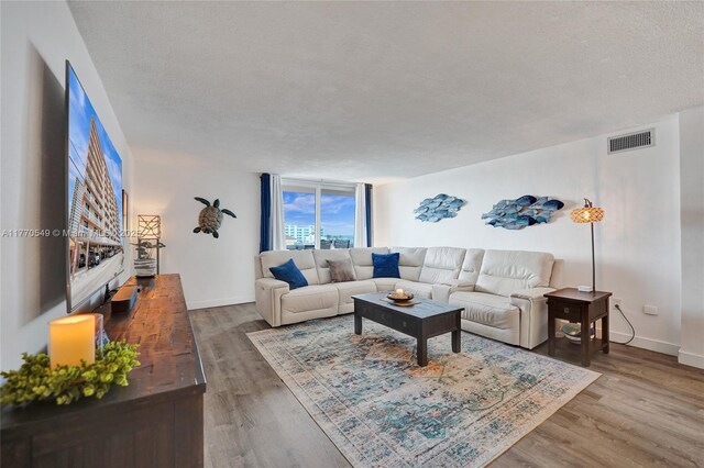 801 S Ocean Dr Unit 604, Hollywood, FL 33019 - living room featuring baseboards, a textured ceiling, visible vents, and wood finished floors