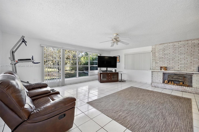 tiled living room with a brick fireplace, a textured ceiling, and a ceiling fan