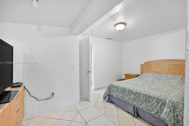 bedroom with light tile patterned floors, visible vents, and a textured ceiling