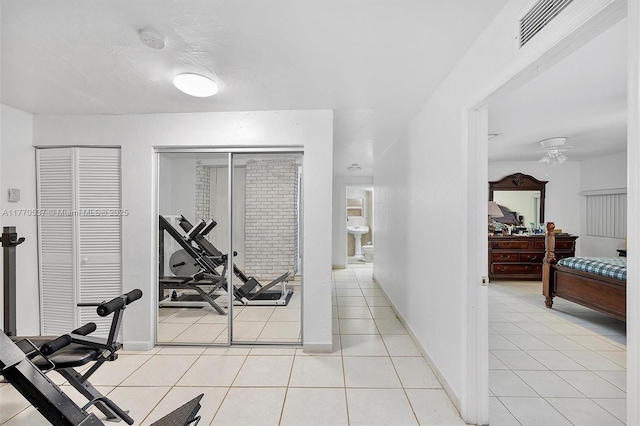 exercise room featuring a ceiling fan, light tile patterned floors, baseboards, and visible vents