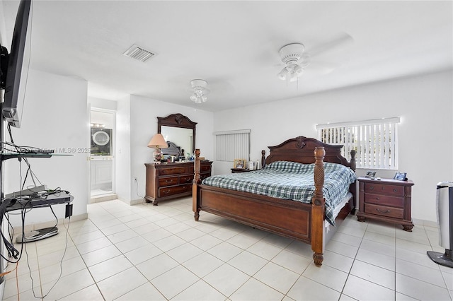 bedroom with light tile patterned flooring, visible vents, and ensuite bathroom