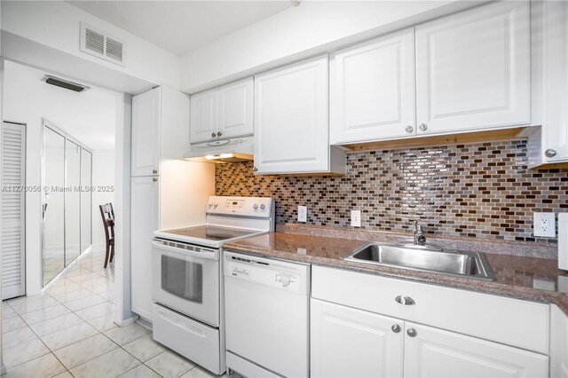 kitchen featuring white appliances, under cabinet range hood, a sink, visible vents, and white cabinets