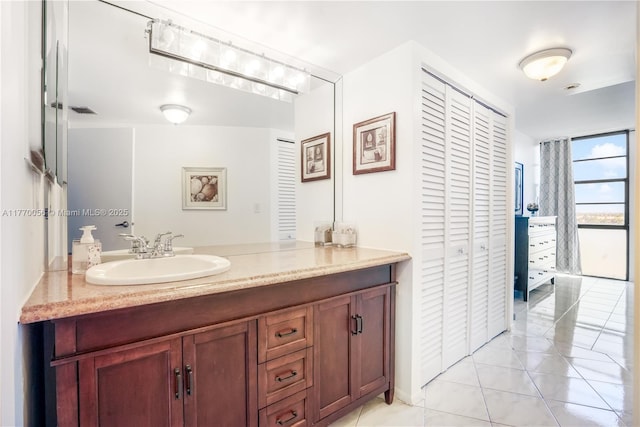 bathroom with a closet, visible vents, tile patterned floors, and vanity