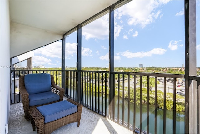 sunroom featuring a water view