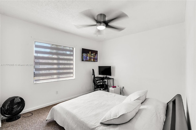 carpeted bedroom featuring baseboards, a textured ceiling, and a ceiling fan
