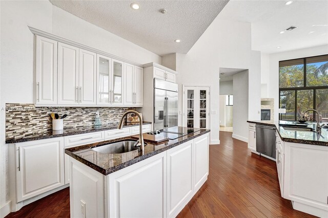 3320 Bridle Path Ln, Weston, FL 33331 - kitchen with stainless steel appliances, backsplash, dark stone countertops, white cabinetry, and recessed lighting