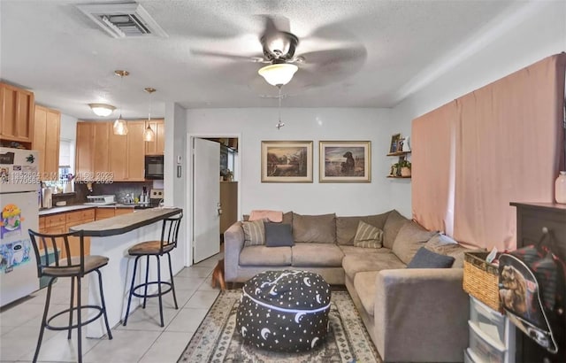 1538 NE 5th Ave, Fort Lauderdale, FL 33304 - living room with a textured ceiling, visible vents, ceiling fan, and light tile patterned floors