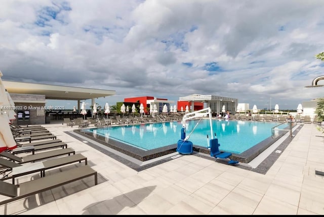 pool featuring a water slide and a patio