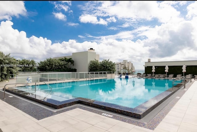 pool with fence and a patio