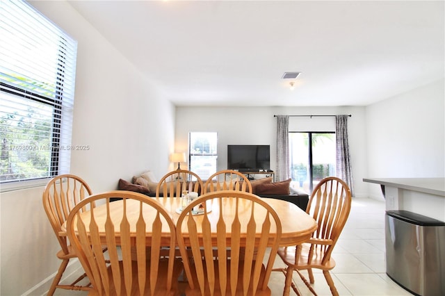 dining area with light tile patterned floors, a wealth of natural light, baseboards, and visible vents