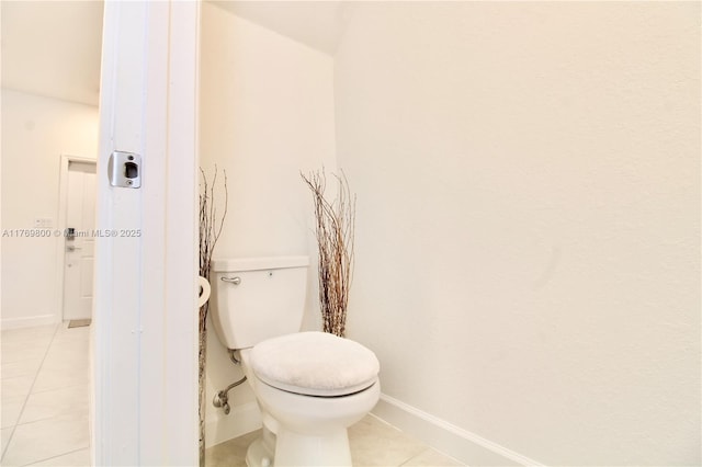 bathroom featuring baseboards, toilet, and tile patterned flooring