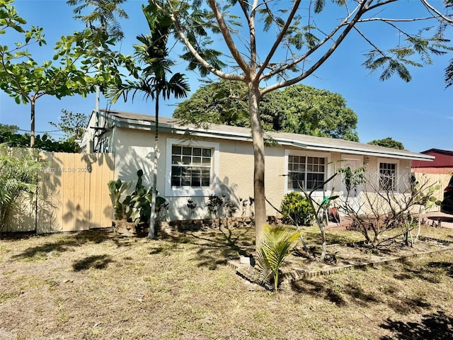 view of front of home featuring stucco siding and fence