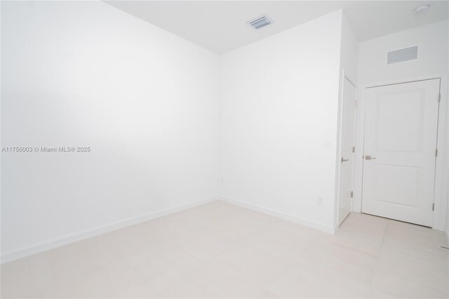 unfurnished room featuring baseboards and visible vents