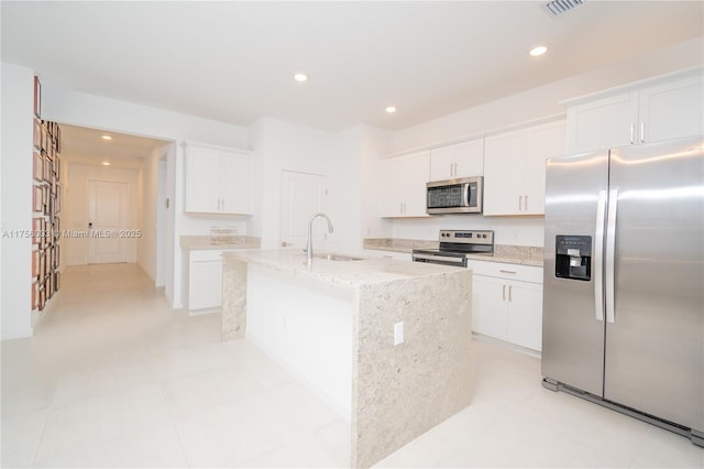 kitchen with an island with sink, white cabinetry, a sink, and appliances with stainless steel finishes
