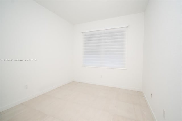 spare room with baseboards