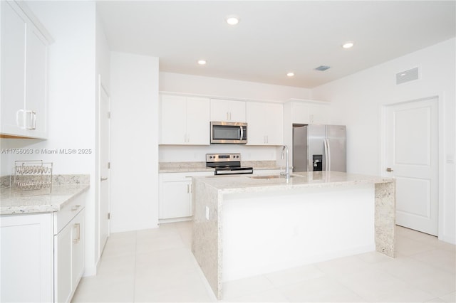 kitchen with white cabinetry, a sink, an island with sink, visible vents, and appliances with stainless steel finishes