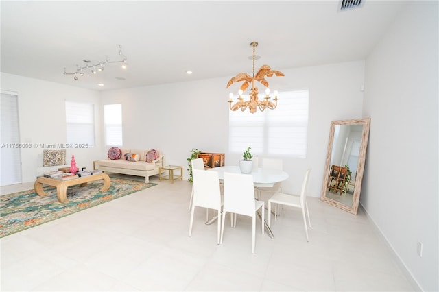 dining area with baseboards, visible vents, and an inviting chandelier