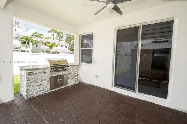 view of patio featuring a grill, ceiling fan, exterior kitchen, and fence