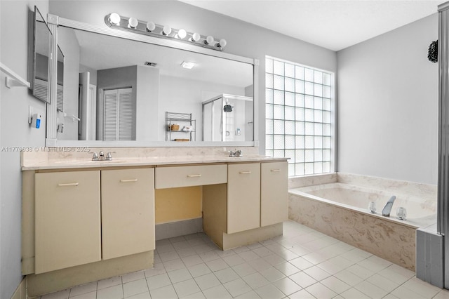 bathroom featuring a garden tub, double vanity, tile patterned flooring, a shower stall, and a sink