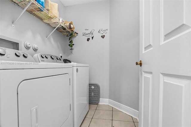 laundry area featuring laundry area, baseboards, light tile patterned flooring, and separate washer and dryer