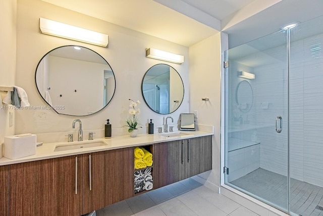 bathroom with double vanity, a shower stall, tile patterned flooring, and a sink