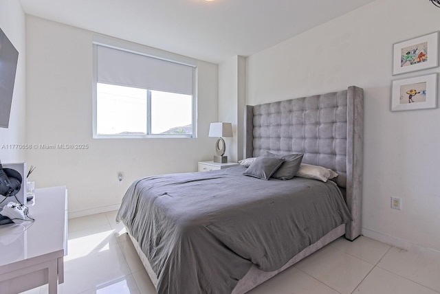 bedroom featuring light tile patterned flooring and baseboards