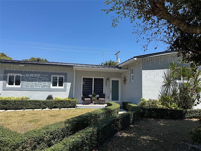 exterior space featuring stucco siding, metal roof, and a standing seam roof