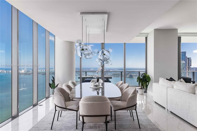 dining room featuring a city view, floor to ceiling windows, a chandelier, marble finish floor, and a water view