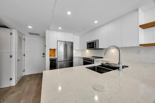 1901 Brickell Ave Unit B2304, Miami, FL 33129 - kitchen featuring appliances with stainless steel finishes, open shelves, light stone counters, white cabinets, and recessed lighting