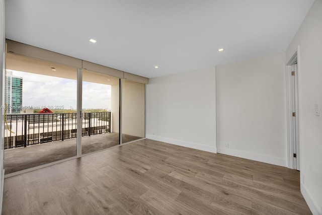 1901 Brickell Ave Unit B2304, Miami, FL 33129 - spare room featuring wood finished floors, a wall of windows, and recessed lighting