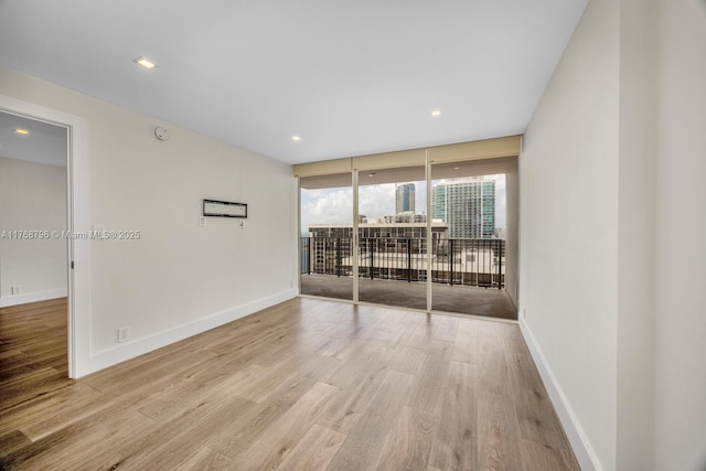 1901 Brickell Ave Unit B2304, Miami, FL 33129 - unfurnished room featuring wood finished floors, recessed lighting, a wall of windows, and a smoke detector
