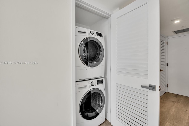 1901 Brickell Ave Unit B2304, Miami, FL 33129 - washroom featuring stacked washing machine and dryer and wood finished floors