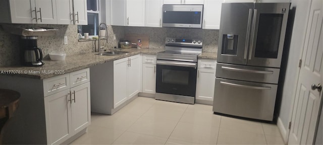 840 NE 32nd Ct, Pompano Beach, FL 33064 - kitchen featuring stainless steel appliances, a sink, backsplash, and light stone countertops