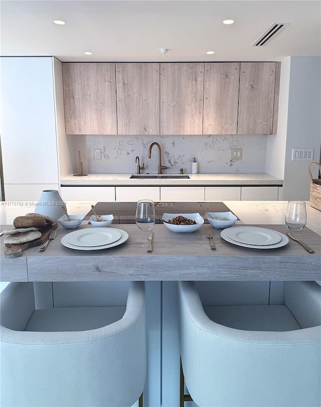19707 Turnberry Way Unit 6E, Aventura, FL 33180 - kitchen featuring decorative backsplash, light brown cabinets, modern cabinets, and a sink