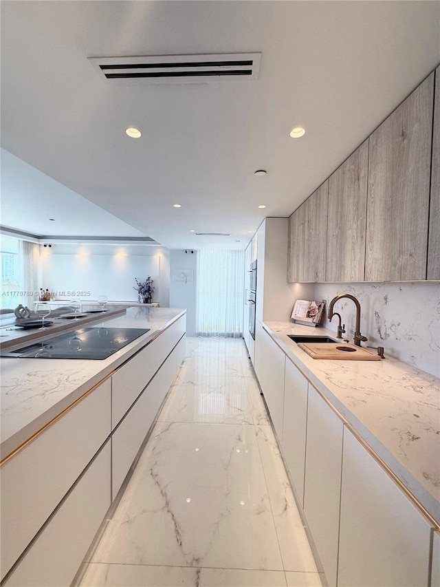 19707 Turnberry Way Unit 6E, Aventura, FL 33180 - kitchen with a sink, black electric stovetop, modern cabinets, marble finish floor, and recessed lighting