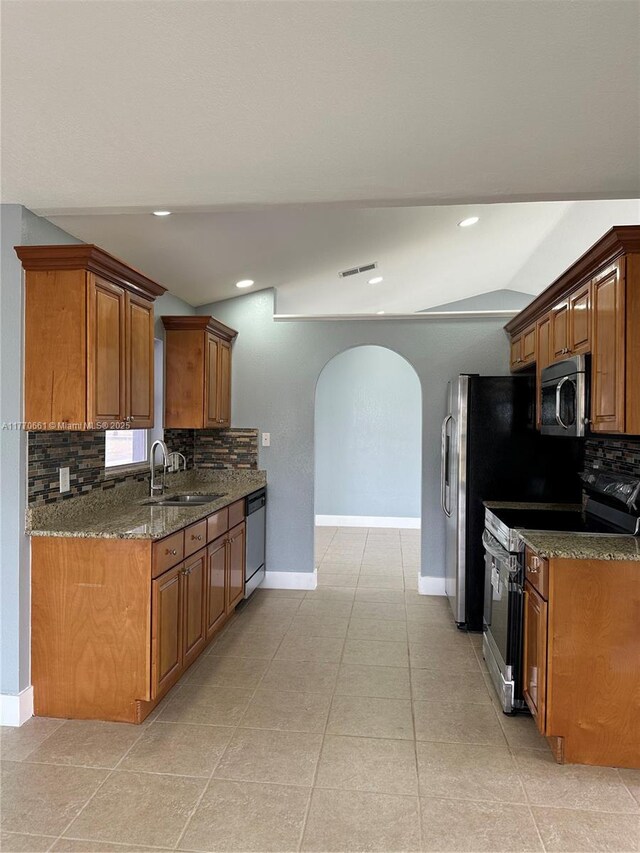 1715 NE 2nd Ave, Cape Coral, FL 33909 - kitchen featuring stainless steel microwave, range with electric stovetop, a sink, arched walkways, and backsplash