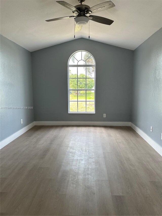 1715 NE 2nd Ave, Cape Coral, FL 33909 - unfurnished room with lofted ceiling, wood finished floors, a ceiling fan, and baseboards