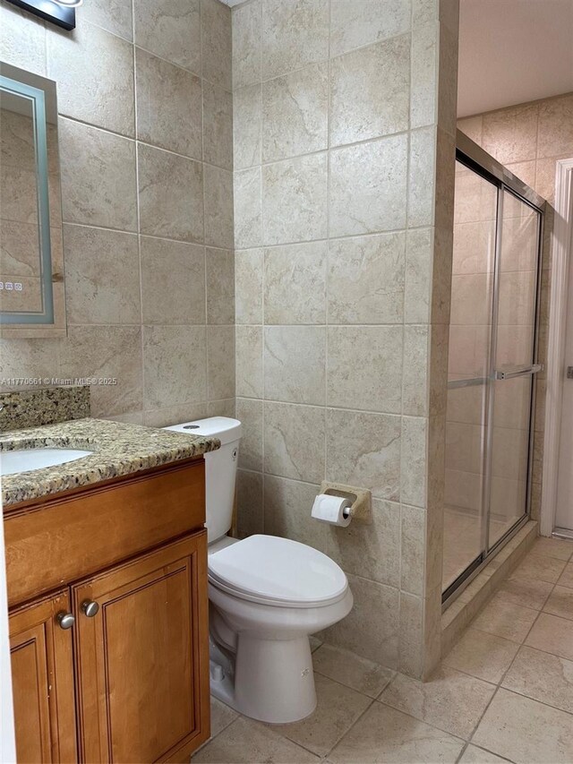 1715 NE 2nd Ave, Cape Coral, FL 33909 - full bathroom with tile walls, tile patterned floors, a stall shower, vanity, and toilet