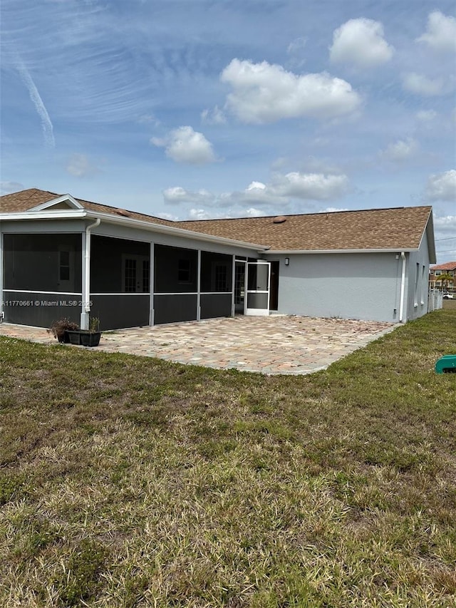 1715 NE 2nd Ave, Cape Coral, FL 33909 - rear view of house featuring a sunroom, a patio, a lawn, and stucco siding
