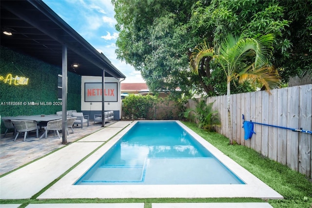 view of swimming pool featuring a patio, outdoor dining area, a fenced backyard, and a fenced in pool