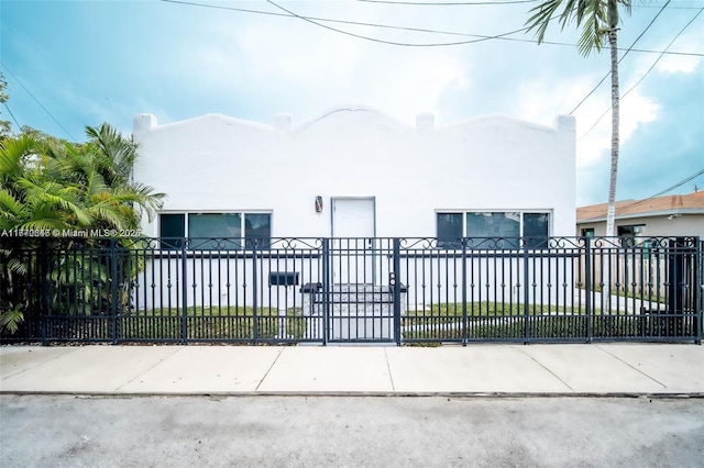 view of front of home with stucco siding and a fenced front yard