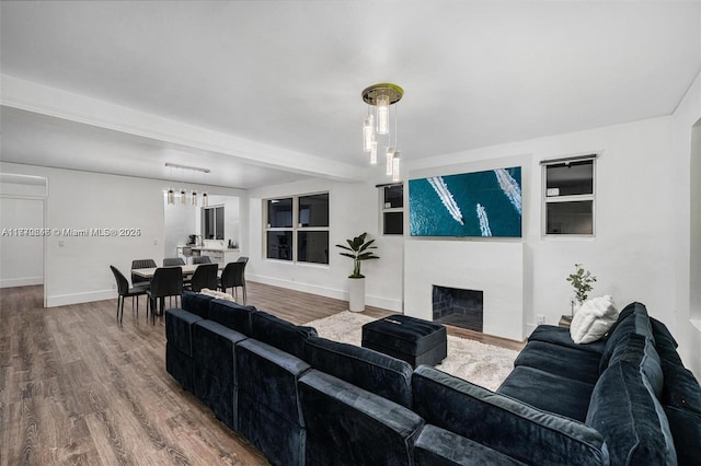 living area featuring baseboards, a fireplace, and wood finished floors