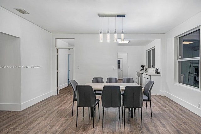 dining area featuring baseboards, visible vents, and wood finished floors