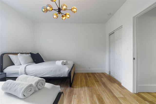 1114 SW 11th Ave, Miami, FL 33129 - bedroom featuring a chandelier, light wood-style flooring, and a closet