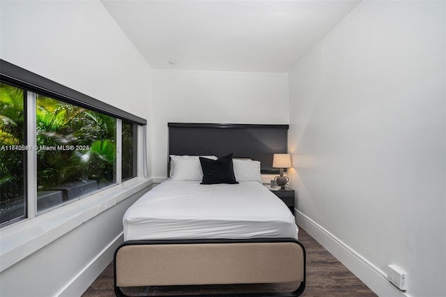 bedroom with baseboards and wood finished floors