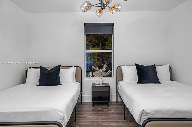 bedroom featuring wood finished floors and an inviting chandelier