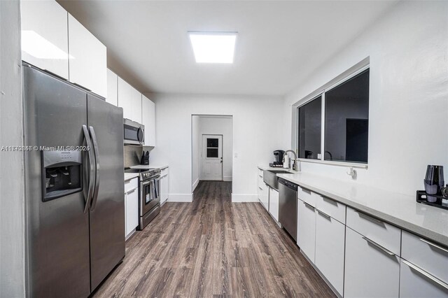 1114 SW 11th Ave, Miami, FL 33129 - kitchen featuring stainless steel appliances, white cabinetry, dark wood-style floors, light countertops, and a sink